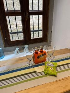 a table with two wine glasses and a box of apopka at Kate's Townhouse in Buzet