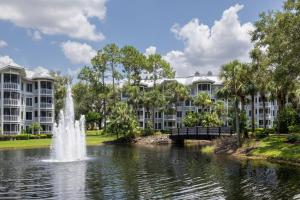 uma fonte num lago em frente a edifícios de apartamentos em Marriott's Cypress Harbour Villas em Orlando