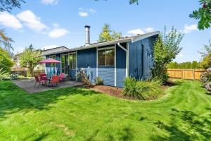 a blue house with a lawn at Cozy Tacoma Home with Patio, Walk to Beach! in Tacoma