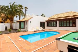 una piscina en el patio trasero de una casa con mesa de billar en Villa Relax Deluxe Private Pool Corralejo By Holidays Home, en Corralejo