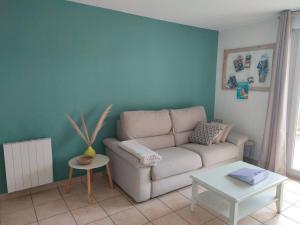 ein Wohnzimmer mit einem Sofa und einem Tisch in der Unterkunft appartement en rez-de-chaussée et terrasse sans vis a vis in Canet-en-Roussillon