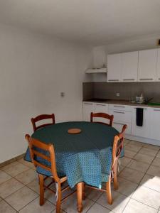 a kitchen with a table and chairs and a kitchen with white cabinets at appartement en rez-de-chaussée et terrasse sans vis a vis in Canet-en-Roussillon