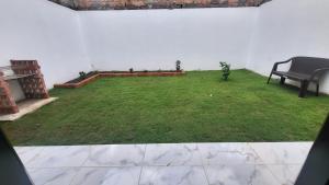 un patio verde con un banco en una habitación en Bello apartamento familiar en Pitalito en Pitalito