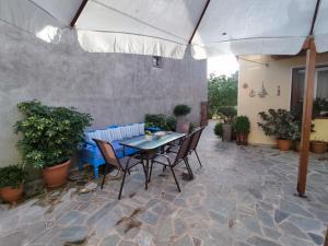 a patio with a table and chairs under an umbrella at Maria Pantermou Rooms in Skala Eresou