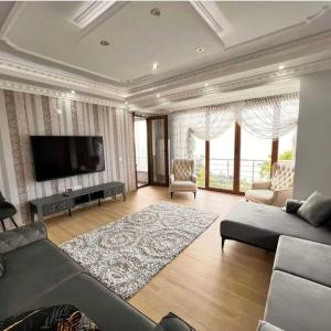 uma sala de estar com um sofá e uma televisão de ecrã plano em Denize Sıfır 2 Yatak Odalı ve 2 Çekyatlı Bahçeli Ev - Seafront, 2 bedroom, 2 sofa bed house with big garden em Rize