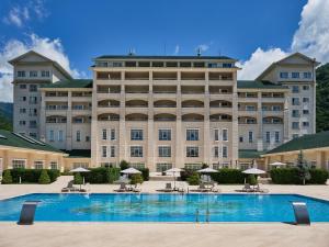 un gran edificio con una gran piscina frente a él en Qafqaz Riverside Hotel, en Gabala