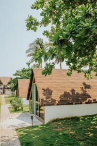 een huis met een bruin dak bij Los Olivos La Playa Hotel y Restaurante in Escuintla