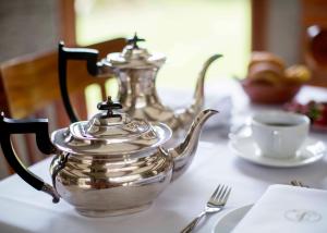 a table with two silver tea pots and a cup at EL TORREAL in Cayambe