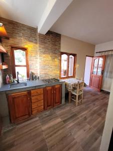 eine Küche mit Holzschränken, einer Spüle und einem Tisch in der Unterkunft Wasy de Purmamarca in Purmamarca