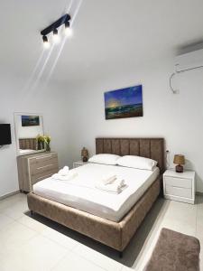 um quarto com uma cama grande e lençóis brancos em Villa Kanto (Holiday apartments and rooms) em Vlorë