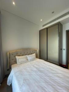 um quarto com uma grande cama branca e 2 almofadas em Losso Wynn em Ho Chi Minh