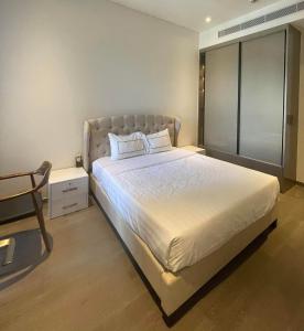 um quarto com uma cama grande e uma cadeira em Losso Wynn em Ho Chi Minh