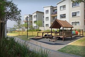 a park with a bench and a gazebo at Lea's Furnished Apartments - Dainfern in Sandton