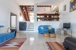 a living room with blue couches and a chalkboard at Pousada Tehau Guest House in Búzios