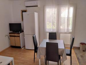 una sala da pranzo con tavolo e frigorifero di Apartments with a parking space Orebic, Peljesac - 20250 a Orebić (Sabbioncello)