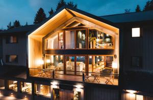 ein Haus mit großen Glasfenstern und einer Terrasse in der Unterkunft Refugio Knapp in San Carlos de Bariloche