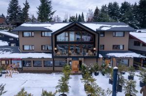 une grande maison recouverte de neige dans l'établissement Refugio Knapp, à San Carlos de Bariloche