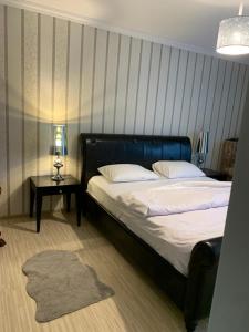 ein Schlafzimmer mit einem Bett und einem Tisch mit einer Lampe in der Unterkunft Pensiunea Sun Victor in Baile Felix