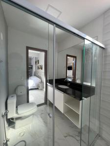 uma casa de banho com um WC, um lavatório e um espelho. em Enseada Beach Hotel no Guarujá