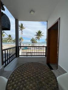 um quarto com uma varanda com vista para a praia em Enseada Beach Hotel no Guarujá