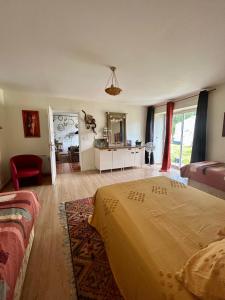 la maison d'hôtes des Charentes في Les Touches-de-Périgny: غرفة نوم مع سرير وغرفة معيشة