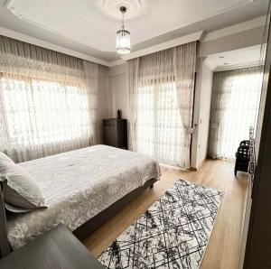 een slaapkamer met een groot bed met gordijnen en een tapijt bij Denize Sıfır 2 Yatak Odalı ve 2 Çekyatlı Bahçeli Ev - Seafront, 2 bedroom, 2 sofa bed house with big garden in Rize