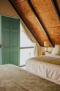a bedroom with two beds and a green door at Los Olivos La Playa Hotel y Restaurante in Escuintla