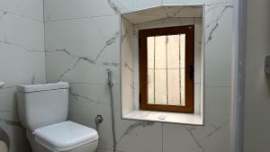 a bathroom with a toilet and a window at Duplex Mino, Pazari i Vjetër Korçë in Korçë +8 photos