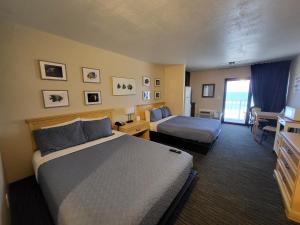 a hotel room with two beds and a desk at Beachside Hotel - Daytona Beach - NO POOL in Daytona Beach