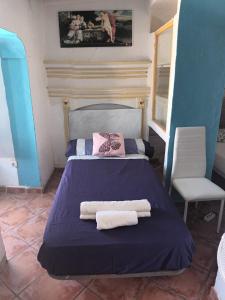a bedroom with a bed with two towels on it at Pension El Torreon in Mojácar