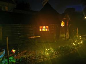 a small house with lights in the yard at night at La cabane du Nuton Ardennais in Tournes