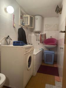 een badkamer met een wasmachine en een wastafel bij Apartman ŽES in Sarajevo