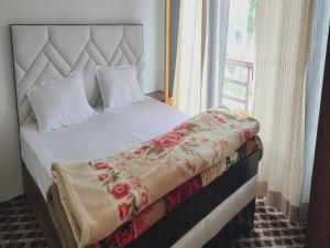 sypialnia z łóżkiem z białą pościelą i oknem w obiekcie POP HOME 81129A Skayil Guest House w mieście Nubra