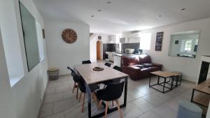 eine Küche und ein Wohnzimmer mit einem Tisch und einem Sofa in der Unterkunft Maison au cœur des Bois in Saint-Martin-de-Sallen