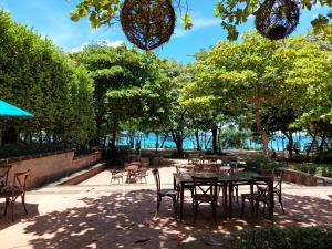 a patio with a table and chairs and trees at Santarena Hotel at Las Catalinas in Playa Flamingo