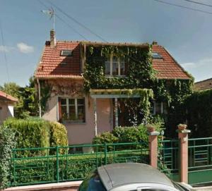 ein Auto, das vor einem Haus mit Efeu parkt in der Unterkunft Rez de jardin de maison avec grand jardin exclusif in Villejuif