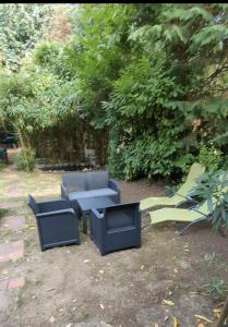 eine Gruppe von Stühlen und Tischen in einem Hof in der Unterkunft Rez de jardin de maison avec grand jardin exclusif in Villejuif + 2 Fotos