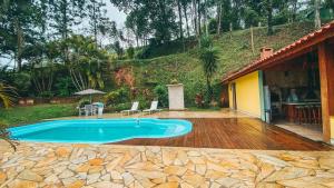 a swimming pool in the backyard of a house at Cabana Refúgio da Mata in Juquitiba
