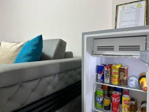 a refrigerator filled with drinks next to a couch at Duplex Mino, Pazari i Vjetër Korçë in Korçë