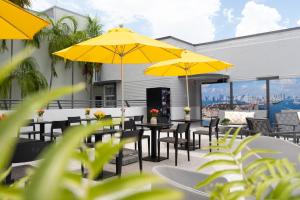 マイアミビーチにあるFashion Boutique Hotelのパティオ(テーブル、椅子、黄色のパラソル付)