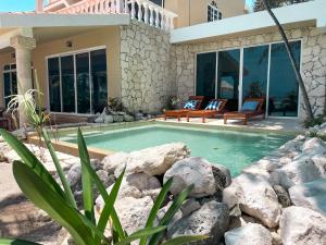 een zwembad met rotsen voor een huis bij Casa Paamul in Playa del Carmen