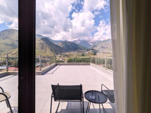 mit Blick auf einen Balkon mit einem Tisch und Stühlen in der Unterkunft Milky Way in Kazbegi