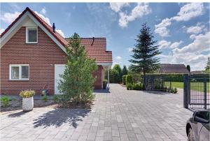 une maison en briques avec une allée et un arbre dans l'établissement Modern Luxury villa, à Zeewolde