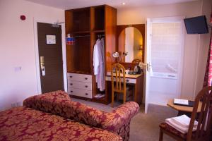 a room with a bedroom with a vanity and a desk at The Belfray Country Inn in Derry Londonderry