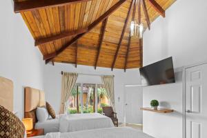 sypialnia z łóżkiem i drewnianym sufitem w obiekcie H4 LAS CABAÑAS w mieście Corozal