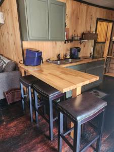 a kitchen with a wooden counter top and stools at 3 bed/2 bath Riverside cabin 