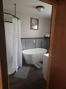 a bathroom with a white tub and a shower at 3 bed/2 bath Riverside cabin 