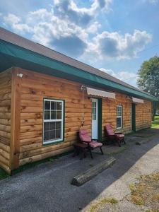 a log cabin with two chairs outside of it at 3 bed/2 bath Riverside cabin 