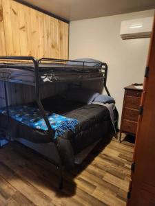 a bedroom with two bunk beds and a wooden floor at 3 bed/2 bath Riverside cabin 