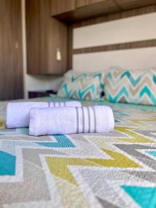 Una cama con dos toallas moradas encima. en Hermoso Apartamento Piso 17 en Cartagena Con Cercania Al Mar y Centro Historico, en Cartagena de Indias